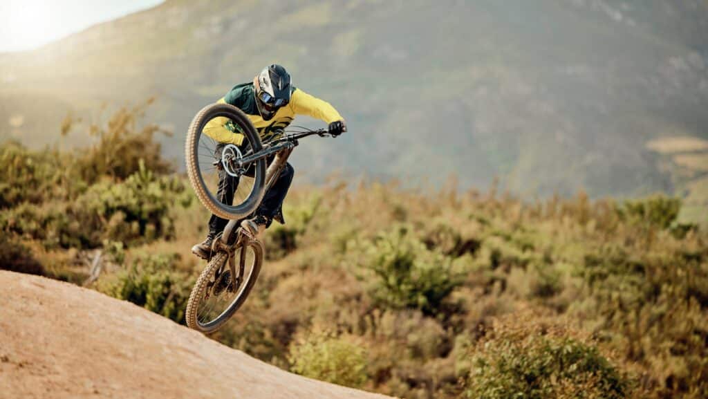 Bicycle, biker and jump in air for competition, mountain biking and extreme sport with helmet, outd